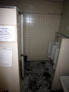 リフォーム前のトイレの様子。粉塵が床に飛散し、汚れているのが分かる。