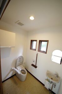トイレの様子。タンクレストイレとなっており、高齢者用の手すりも完備している。